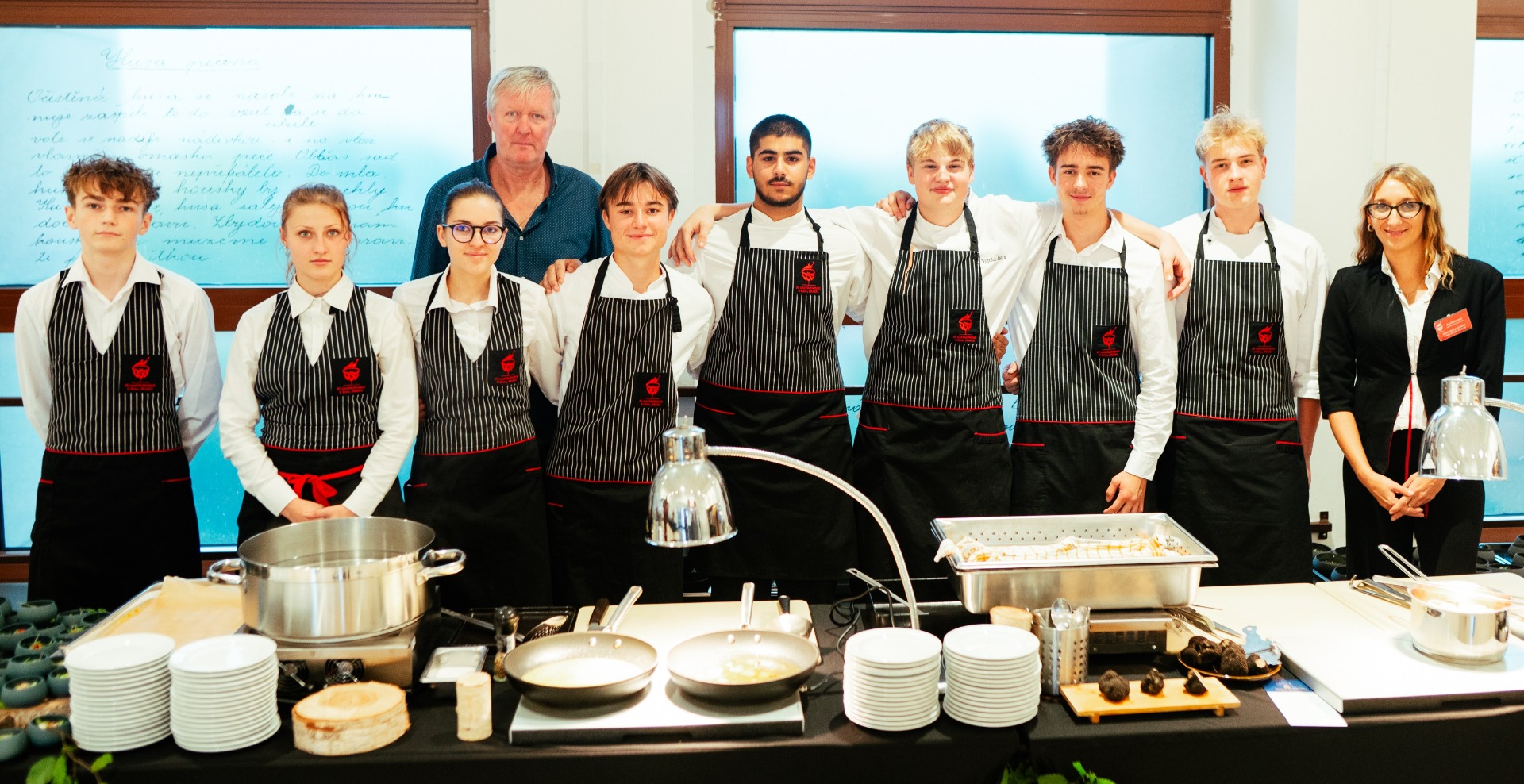 Tým studentů Střední gastronomické školy u Krbu se svými pedagogy při přípravě slavnostní lanýžové večeře pro hosty vernisáže výstavy pořádané Českým lanýžem Asociací.